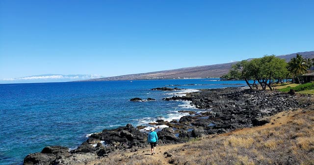 woman walking rocks ocean